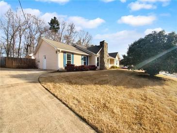 House exterior showcasing a ranch style home with a stone chimney and landscaping at 406 Winterwood Dr, Stockbridge, GA 30281