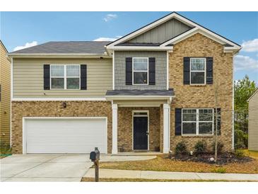 Two-story brick home with a large front yard and attached garage at 3811 River Rock Rd, Lithonia, GA 30038