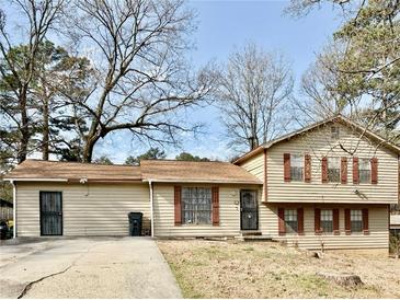 Charming split-level home featuring a well-maintained lawn and classic architectural details at 860 Flat Shoals Rd, Atlanta, GA 30349