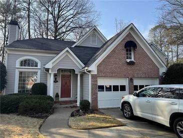 Gray and brick home with two-car garage and landscaped yard at 3025 Park Chase Dr, Alpharetta, GA 30022