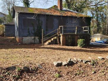 Distressed fixer-upper home with overgrown yard and needs major renovations at 366 Seventh Ave, Scottdale, GA 30079