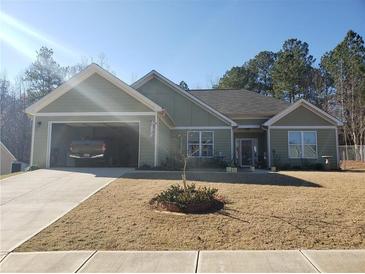 House exterior featuring a two-car garage and well-maintained lawn at 110 Sampson Ct, Covington, GA 30016