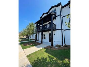 Charming two-story exterior showcases a balcony and well-manicured lawn, blending comfort with modern aesthetics at 391 Lincoln St, Woodstock, GA 30188