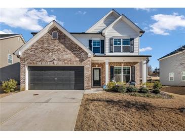 Two story home with brick and white siding, gray garage door, and landscaping at 210 Omega Ct, Dallas, GA 30157