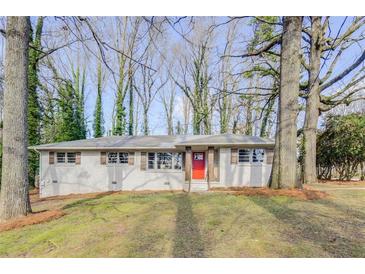 Charming single-story home with a freshly painted brick exterior, red front door, and mature trees at 4388 Coleman Dr, Stone Mountain, GA 30083