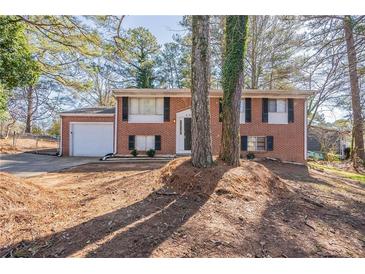 Charming two-story brick home featuring a well-kept front yard and attached garage with a concrete driveway at 5938 Baywood Ln, Riverdale, GA 30296