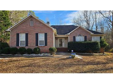 Charming brick home featuring a well-manicured lawn, traditional shutters and neutral colored trim at 219 Thorncrest, Stockbridge, GA 30281