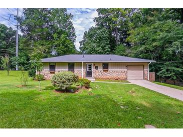 Ranch style home with stone accents and a spacious lawn at 3049 Invermere Woods Ct, Lithonia, GA 30038