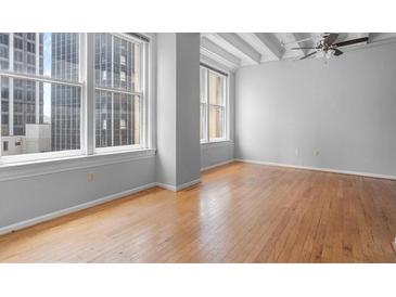 Spacious living room with hardwood floors and large windows offering city views at 32 Peachtree Nw St # 804, Atlanta, GA 30303