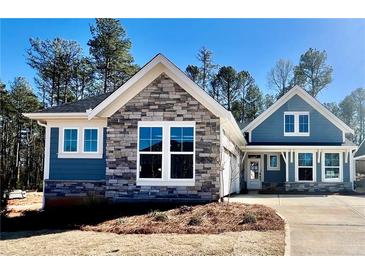 Charming new construction home featuring stone and blue siding, with a spacious driveway and manicured front lawn at 48 Easton Park Blvd, Dallas, GA 30157