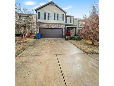 Two-story house with a brown brick and beige vinyl exterior, a two-car garage, and a concrete driveway at 231 Magnaview Dr, Mcdonough, GA 30253