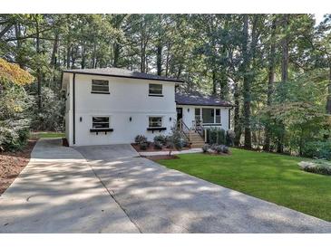 White brick ranch house with a landscaped yard and long driveway at 1770 Austin Dr, Decatur, GA 30032