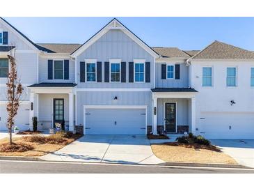 Two-story townhome with gray and white siding, two-car garage, and landscaping at 2133 Kirkham Way, Kennesaw, GA 30152