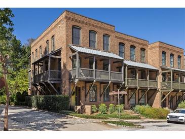 Brick townhome with multiple levels, balconies, and a charming street view at 9060 Selborne Ln, Chattahoochee Hills, GA 30268