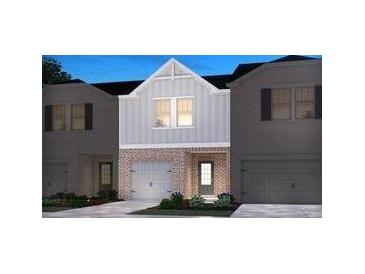 Two-story townhome with gray siding, brick accents, and a two-car garage at 4255 Holland Grove Road Rd, Lawrenceville, GA 30044