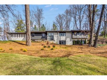 Charming two-story home featuring a landscaped yard with mature trees and a combination of brick and siding at 110 Maryeanna Ne Dr, Atlanta, GA 30342