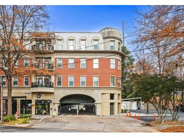 Upscale multi-story building with brick facade and wrought iron balconies overlooking street access to retail and covered parking at 560 Dutch Valley Ne Rd # 209, Atlanta, GA 30324