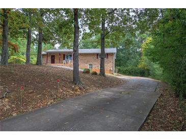 Brick home with an inviting front porch and a long driveway through a treed yard at 72 Bishop Nw Dr, Cartersville, GA 30121