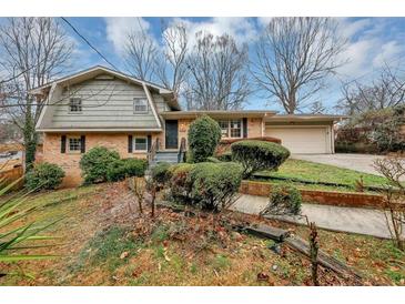 Charming brick home with well-manicured front yard landscaping and an attached two-car garage at 2458 Haverford Way, Decatur, GA 30032