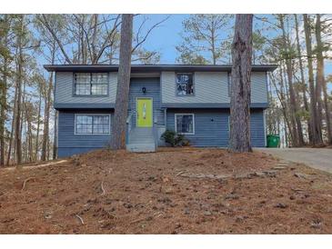 Charming split-level home with a bright green door and a landscaped front yard at 4064 Chimney Ridge Way, Ellenwood, GA 30294