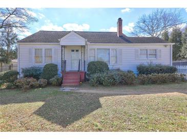 White single story house with red steps, landscaping, and a yard at 153 Hill St, Roswell, GA 30075