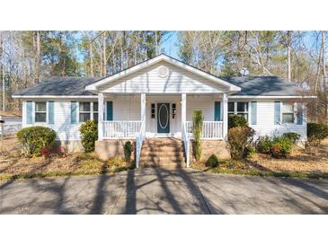 Charming single-story home with a covered front porch and manicured landscaping at 85 Sara Dr, Covington, GA 30016