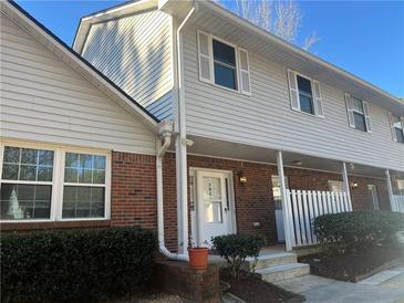 Charming two-story townhouse featuring brick accents, neutral siding, and a well-maintained front yard at 5950 Wintergreen Rd, Norcross, GA 30093