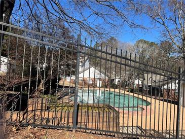 Community pool with surrounding fence and trees at 5950 Wintergreen Rd, Norcross, GA 30093