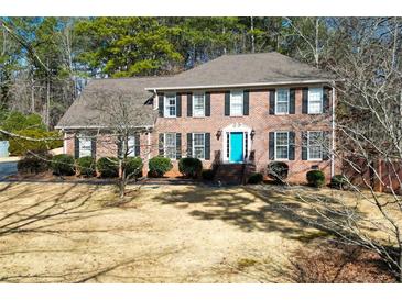 Brick house with a teal door, shutters, and landscaping at 125 Lamberth Lake Dr, Fayetteville, GA 30215
