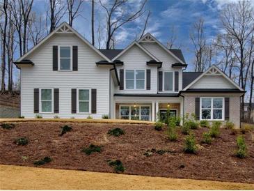 Two-story home with white siding, gray shutters, and brick accents at 7760 Pleasant Hollow Ln, Cumming, GA 30041