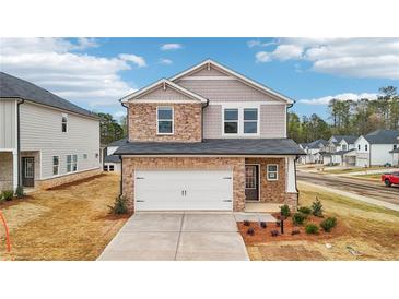 Charming two-story home featuring a stone facade and a two-car garage at 701 Lily Blossom Path Path, Lawrenceville, GA 30045