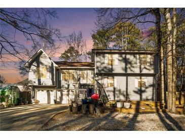 Two-story house with attached two-car garage and deck, surrounded by trees at 1501 Old John Ward Sw Rd, Marietta, GA 30064