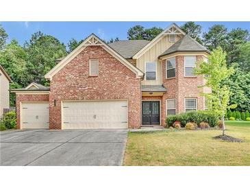Brick two-story house with attached two-car garage and landscaped yard at 1354 Slate Bend Dr, Dacula, GA 30019