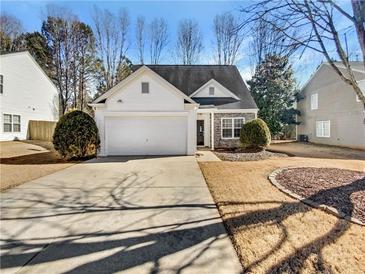 House exterior featuring a white vinyl sided home with a stone accent and a two-car garage at 508 Kensington Park Dr, Canton, GA 30114