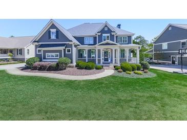 Stunning home featuring a manicured lawn, walkway, lush shrubbery, and covered front porch at 535 Crested Hawk Rdg, Canton, GA 30114