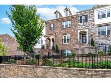 Brick front townhouse with black iron railings and landscaping at 4196 Morrison Way # 11, Atlanta, GA 30341