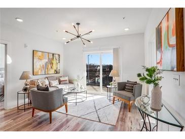 Bright living room with hardwood floors, comfy seating, and access to a balcony at 525 Parkway Ne Dr # 320, Atlanta, GA 30308