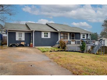 Ranch style home with gray siding, deck, and spacious yard at 2515 Impala Dr, Cumming, GA 30041