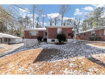 Brick ranch house with attached garage, landscaped yard, and snow on the ground at 1833 Boulderview Se Dr, Atlanta, GA 30316