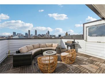 Stunning rooftop deck with outdoor seating, a grill, a fire pit, and city views of the downtown skyline at 75 Boulevard Ne # 1, Atlanta, GA 30312