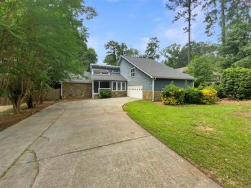 Charming home featuring a stone facade and a well-manicured lawn, complemented by a lengthy driveway at 2781 Interlaken Dr, Marietta, GA 30062