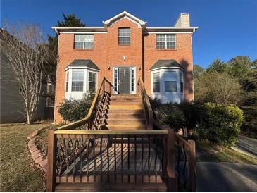 Brick two-story house with a wooden deck and stairs at 5226 Oaktree Trl, Lithonia, GA 30038