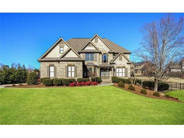 Beautiful two-story brick home boasts a lush green lawn and manicured landscaping at 2602 Alcovy Club Dr, Dacula, GA 30019