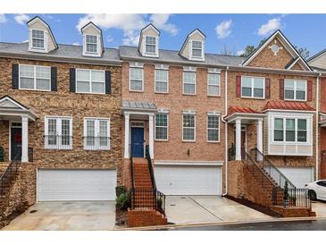 Charming townhome exterior featuring brick facade, private entrances, and attached garages for convenient parking at 3901 Old Atlanta Station Se Dr, Atlanta, GA 30339