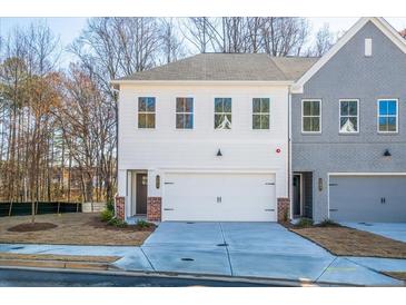 Two-story townhome with white and gray siding, two-car garage, and landscaped lawn at 151 Bluffington Way, Marietta, GA 30066