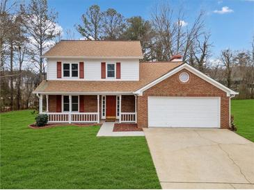 Brick house with a two-car garage and a well-maintained lawn at 4496 Whitt Station Nw Run, Acworth, GA 30101