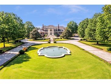 Stunning estate with circular drive, manicured lawn, and elegant fountain at 5200 Moore Rd, Suwanee, GA 30024
