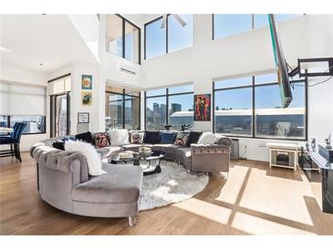 Spacious living room with large windows, city views, and a circular sectional sofa at 260 18Th Nw St # 10226, Atlanta, GA 30363