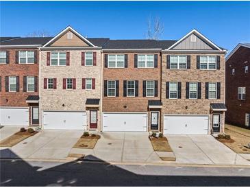 Three-story townhouses with brick exteriors and attached garages at 3075 Westpoint Cir, Snellville, GA 30078