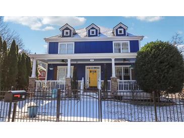 Charming two-story home with a blue exterior, bright yellow door, and inviting front porch at 930 Custer St, Atlanta, GA 30354